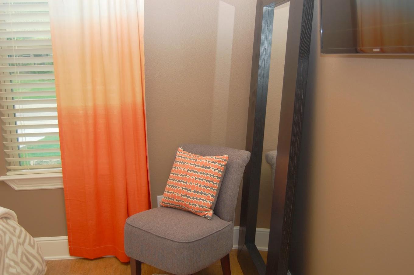 оранжевые шторы омбре в контрасте с нейтральным дизайном комнаты